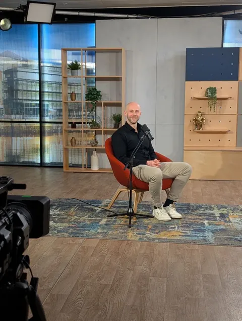 Mick Brands seated in a studio interview setting